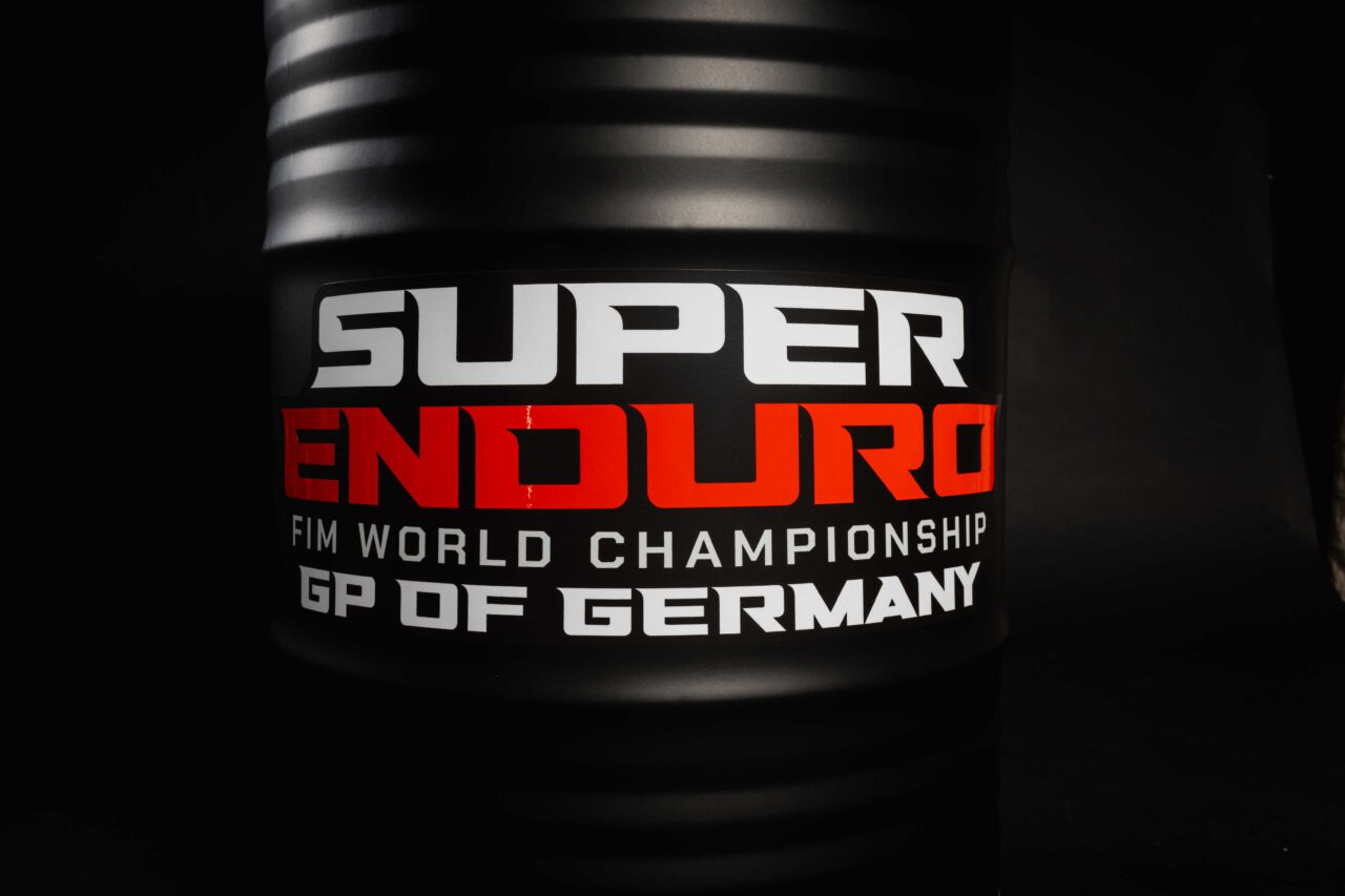 Schwarz-mattes Superenduro Stehfass von der Fasswerkstatt mit der Aufschrift "Super Enduro FIM World Champions GP OF GERMANY"