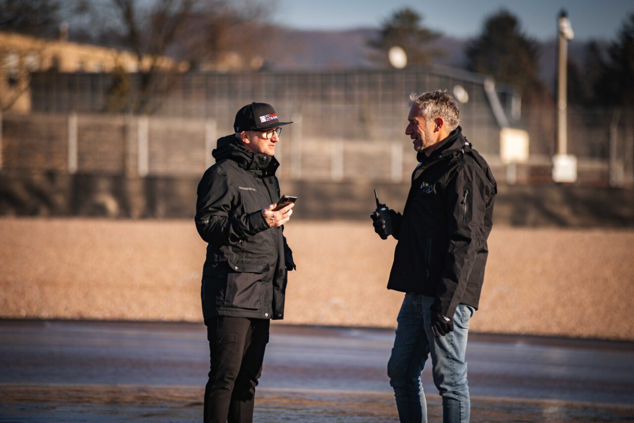 Steve Kirsch und Niki Schelle stehen am Rande der Strecke und unterhalten sich.