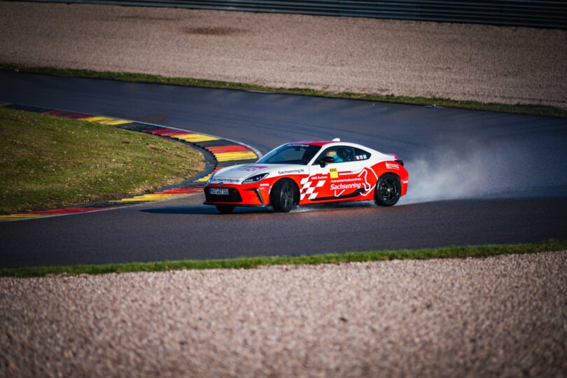 Sportwagen Sachsenring auf präparierter nasser Strecke, welcher in der Kurve driftet.