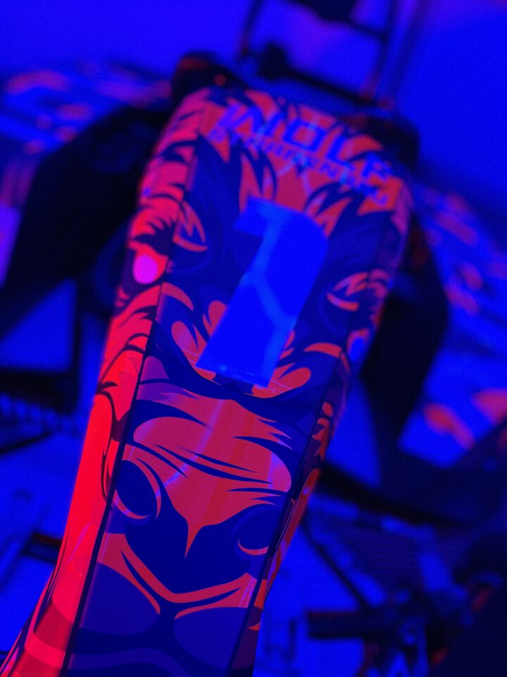 Nahaufnahme eines Rennrads mit auffälligem roten und blauen Muster und der Zahl '1' auf dem Oberrohr.