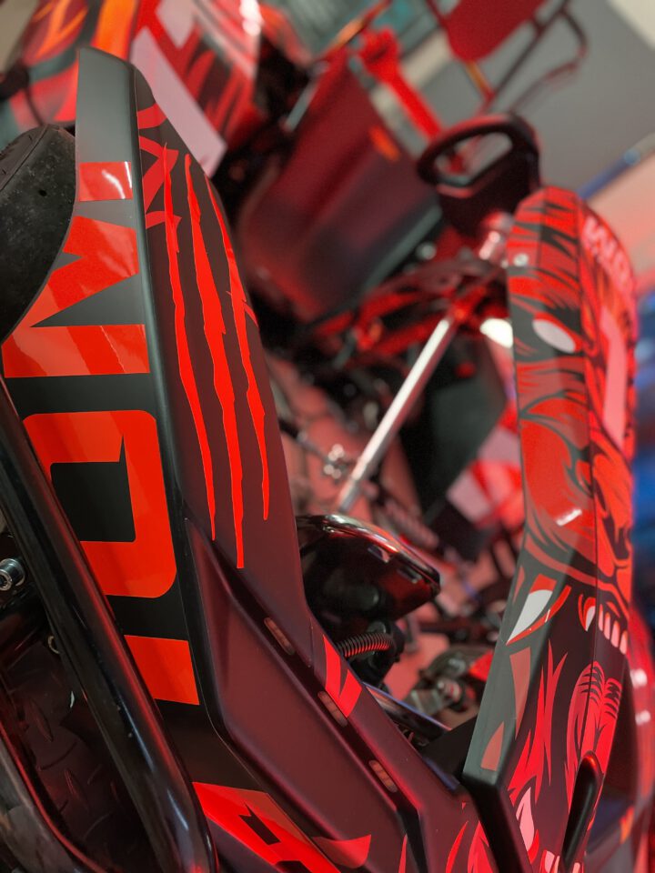 Nahaufnahme eines roten und schwarzen Go-Kart-Karosserieteils mit grafischem Muster und Schriftzug