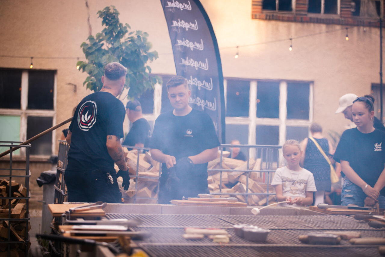 Professionelles Outdoor-Grill-Catering bei einem Firmenevent mit Personal in einheitlicher Teambekleidung.