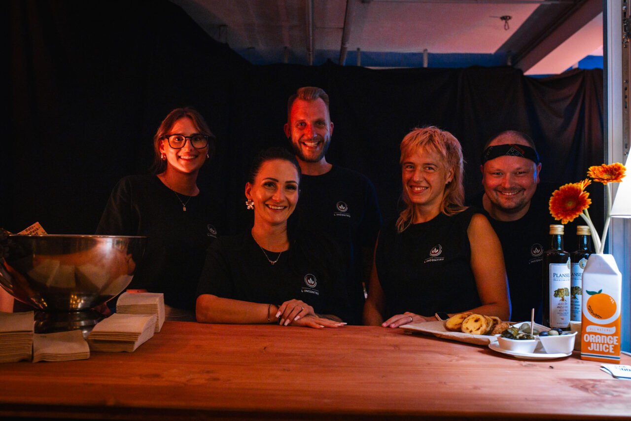 Outdoor-Event mit LED-Screen, Bühnenshow und Zuschauern in einer beleuchteten Industrie-Location bei Dunkelheit.