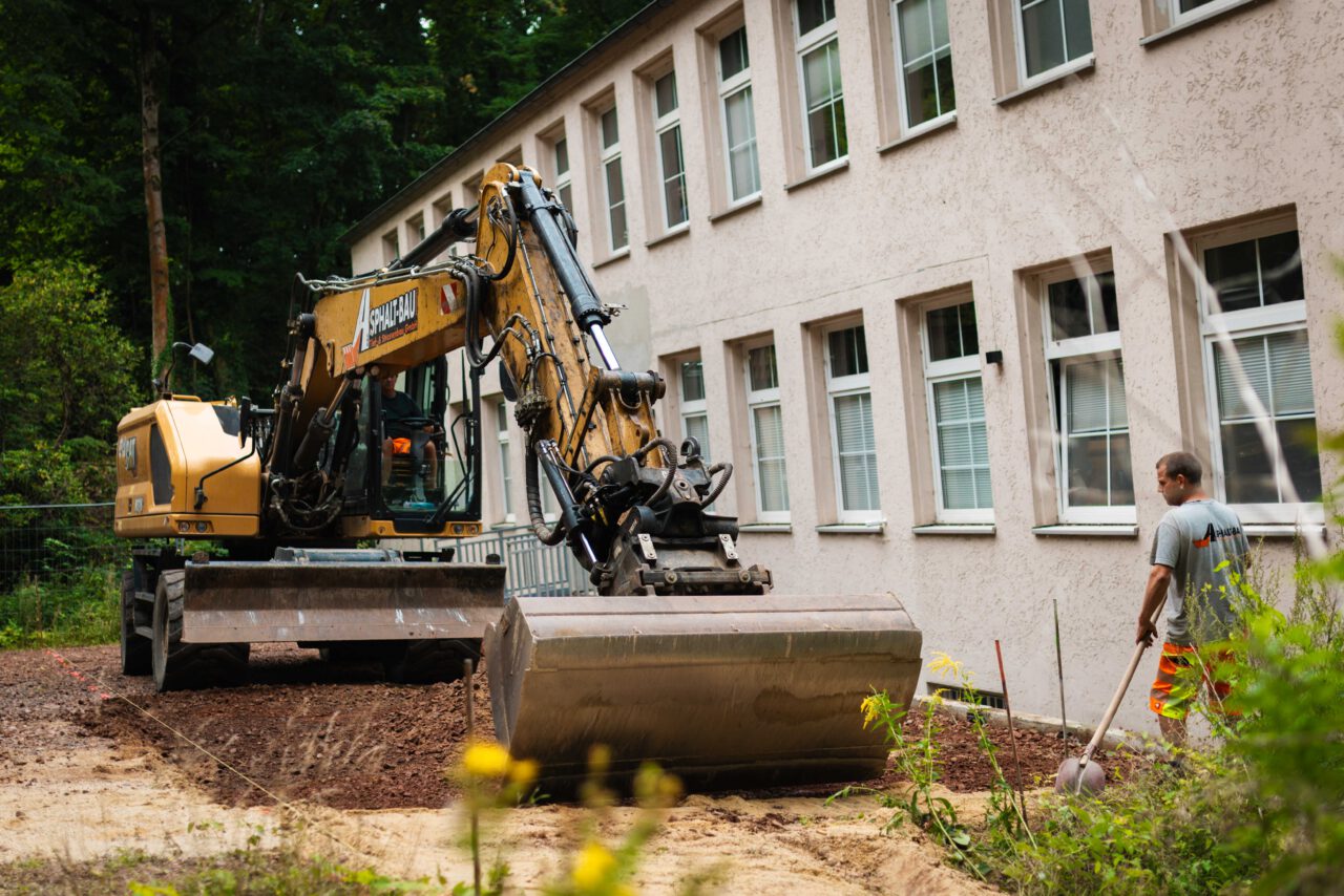 Professionelle Asphaltierung eines Gewerbehofs: Vorarbeiten unter Einsatz eines Baggers von Asphalt-Bau Chemnitz im Einsatz bei der Mindwork GmbH.