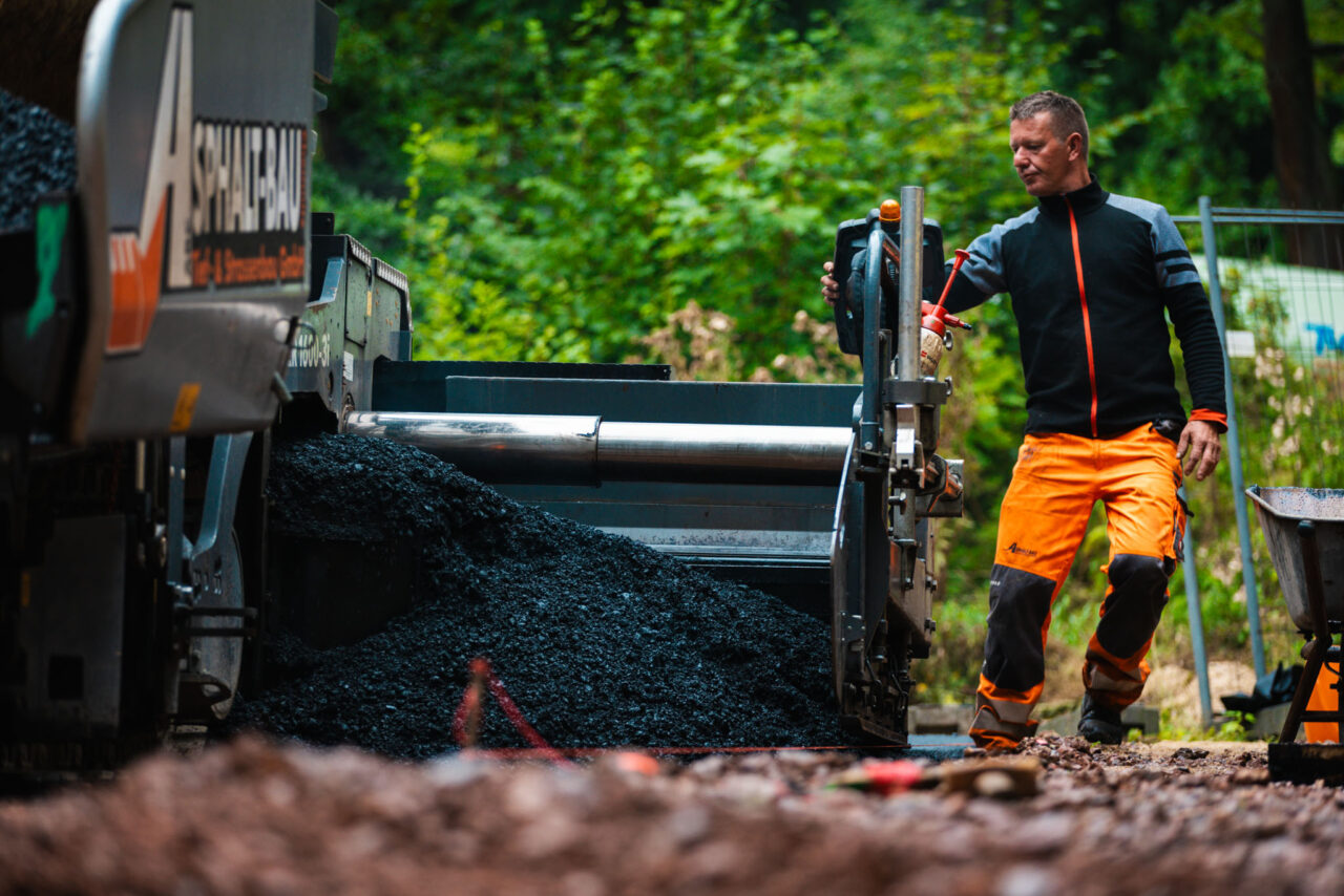 Professionelle Asphaltierung eines Gewerbehofs: Legen des Asphalts von Asphalt-Bau Chemnitz im Einsatz bei der Mindwork GmbH.