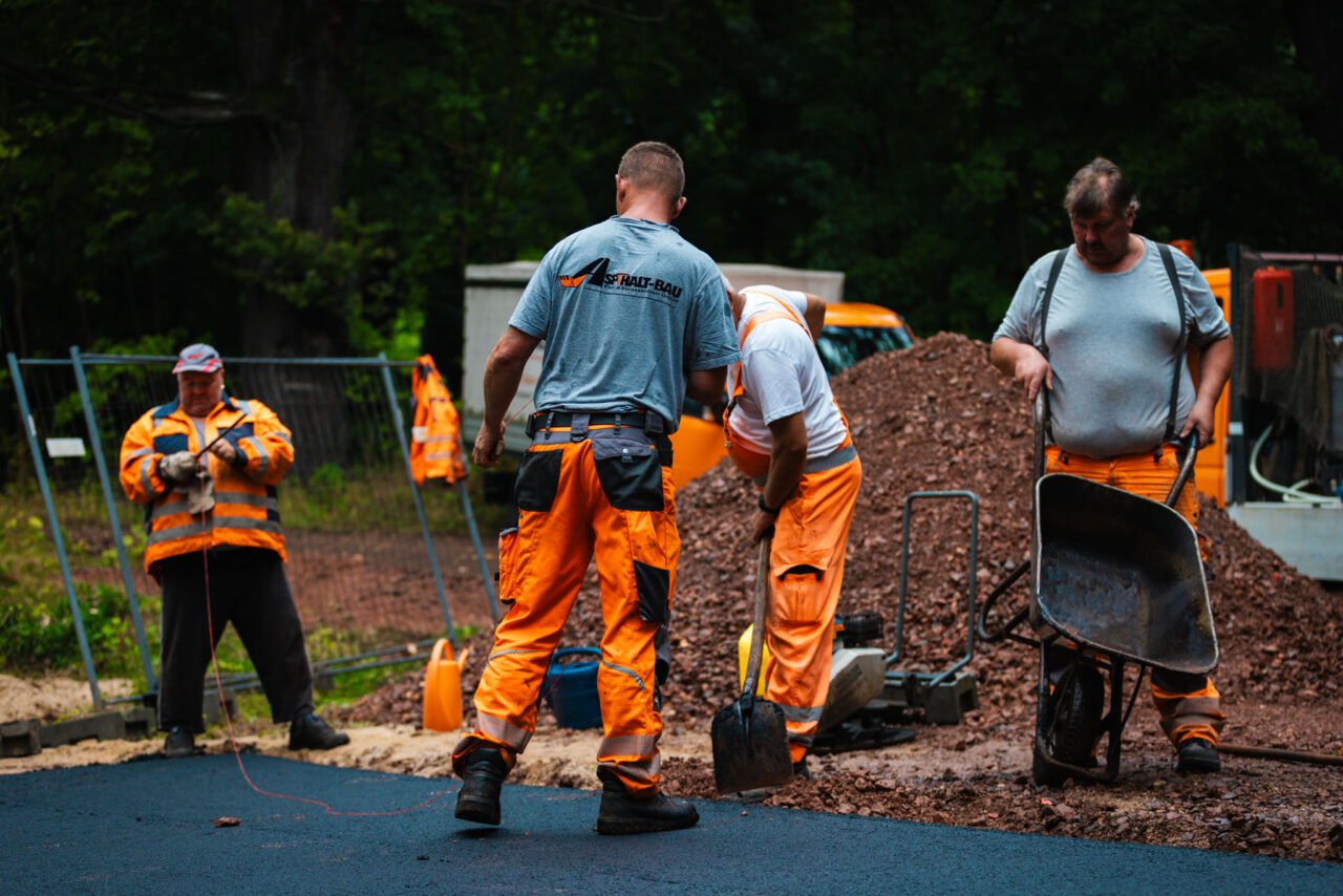 Professionelle Asphaltierung eines Gewerbehofs: Zusammenarbeit des Teams von Asphalt-Bau Chemnitz im Einsatz bei der Mindwork GmbH.