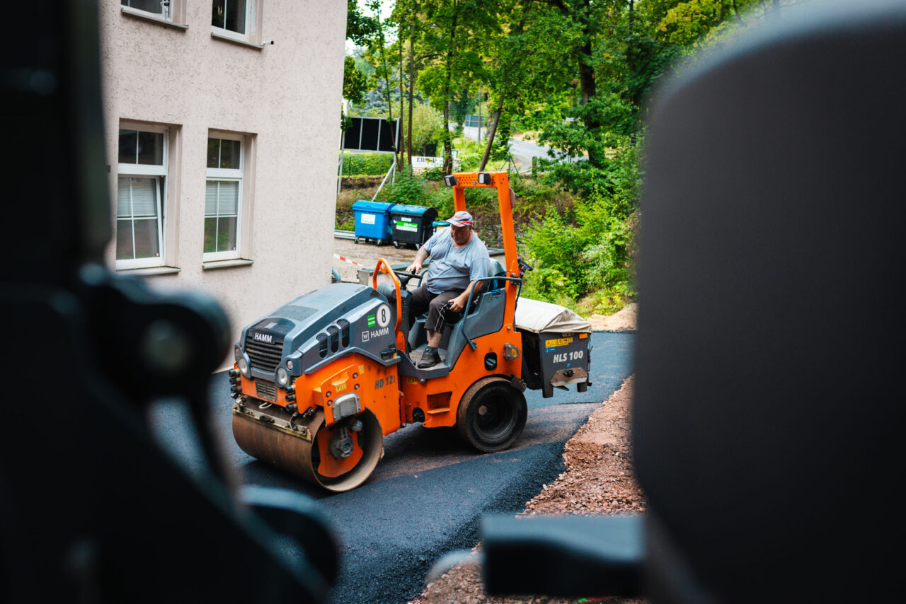 Professionelle Asphaltierung eines Gewerbehofs: Walzen des fertig verlegten Asphalts von Asphalt-Bau Chemnitz im Einsatz bei der Mindwork GmbH.