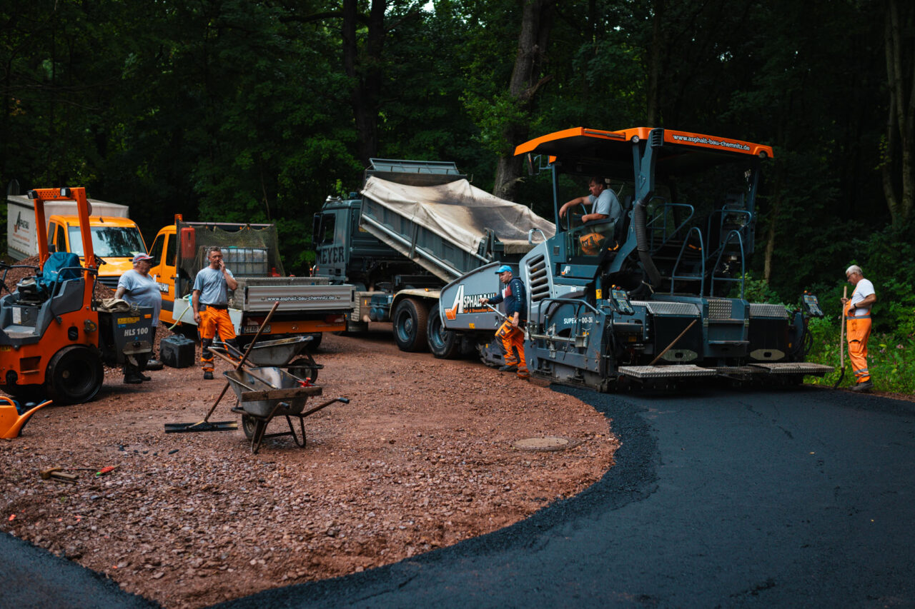 Professionelle Asphaltierung eines Gewerbehofs: Legen des Asphalts von Asphalt-Bau Chemnitz im Einsatz bei der Mindwork GmbH.