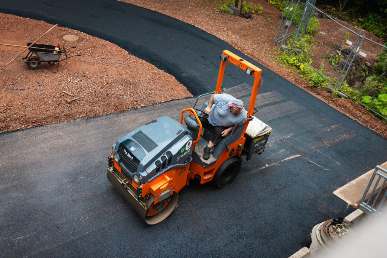 Professionelle Asphaltierung eines Gewerbehofs: Walzen des fertig verlegten Asphalts von Asphalt-Bau Chemnitz im Einsatz bei der Mindwork GmbH.